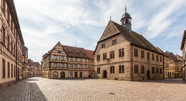 Une photographie réaliste et professionnelle montrant une vue caractéristique de Sarre-Union, commune du Bas-Rhin. La scène doit représenter un élément emblématique ou représentatif de la localité : son centre-ville, une rue principale avec commerces et bâtiments locaux, une perspective urbaine typique, un bâtiment administratif ou culturel reconnaissable de la commune, prise en bon éclairage naturel, sans texte, logo ou filigrane visible. La qualité doit être professionnelle et appropriée pour un site de constructeur immobilier.